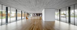 Banc Sabadell Headquarters reception lobby. Textured concrete combines elegantly with wood and glass. Architecture and Interior design by Bach Arquitectes + Antonio Moll