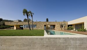 Private House in Girona. Locally sourced natural materials volumes enclose the garden and swimming pool. Architecture and Interior design by Bach Arquitectes + Antonio Moll