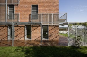 Family house and home office. The brick façade combines with the steel grating in a contemporary fashion. Architecture and Interior design by Bach Arquitectes + Antonio Moll